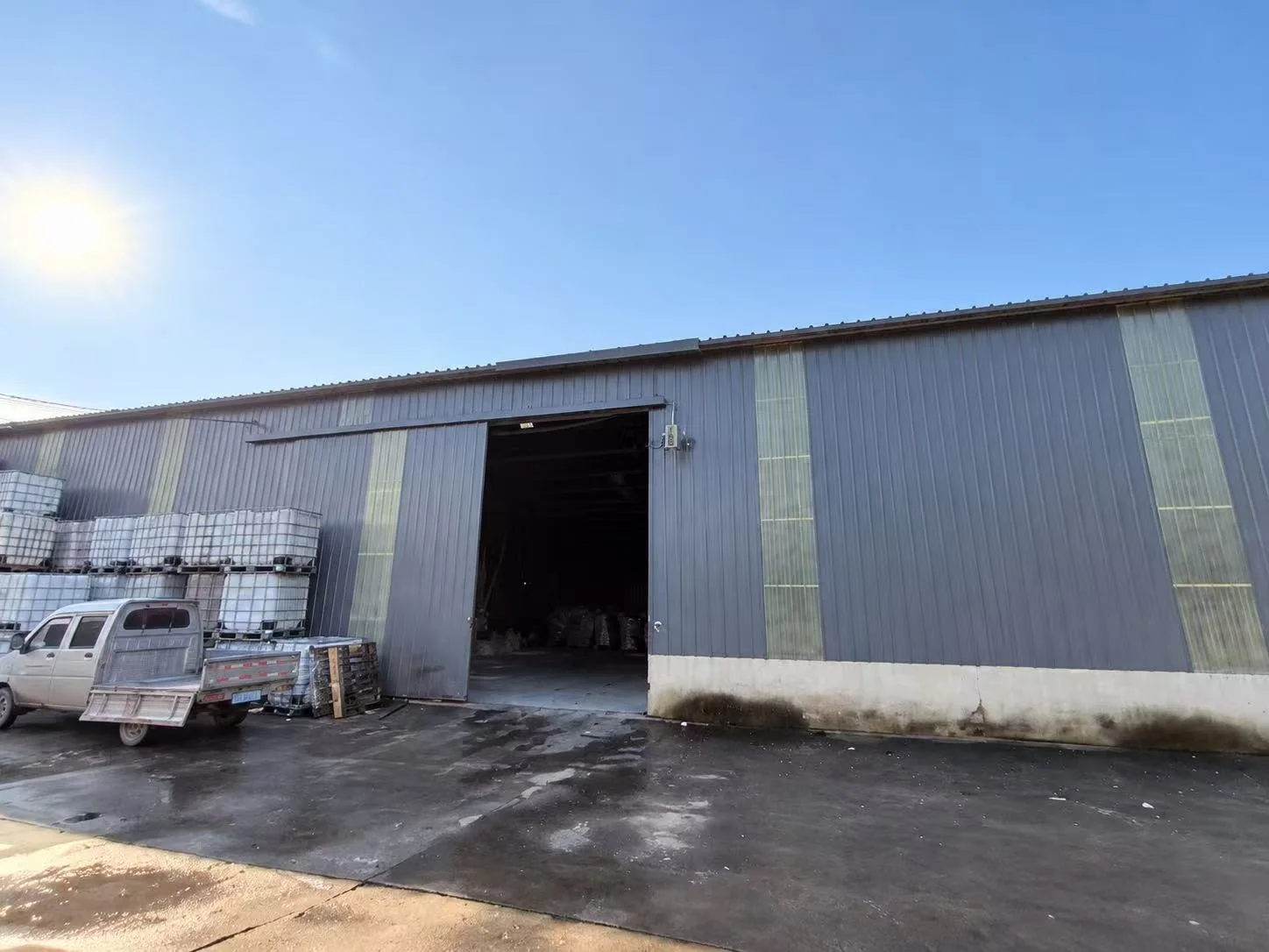 Exterior of the supplied SailinChem facility with bagged-material containers near the entrance